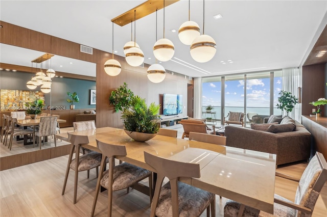 dining area featuring expansive windows and light wood-type flooring