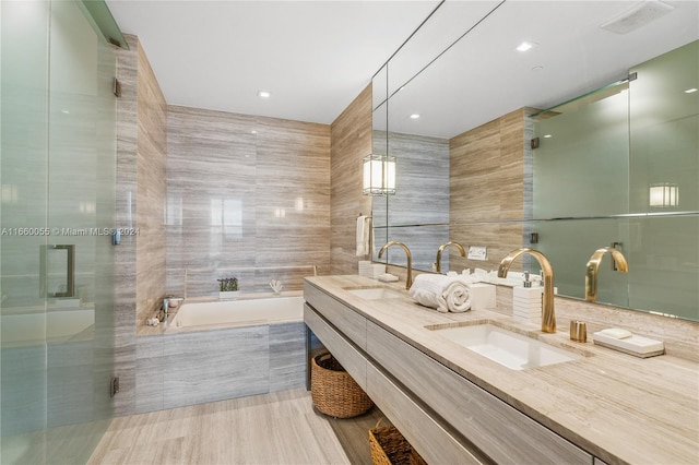 bathroom featuring vanity, separate shower and tub, and tile walls