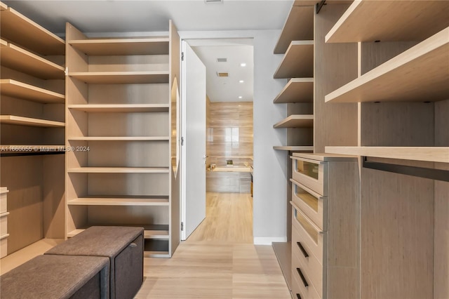 walk in closet with light wood-type flooring