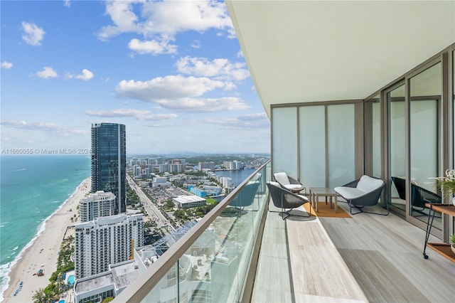 balcony featuring a view of the beach and a water view