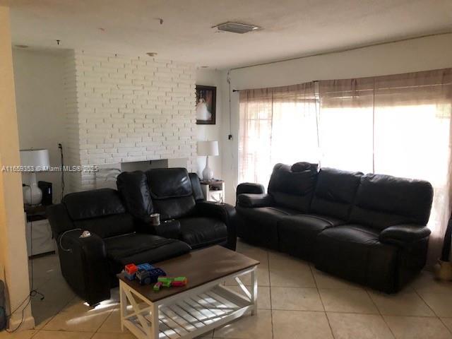 living room with brick wall and light tile patterned floors