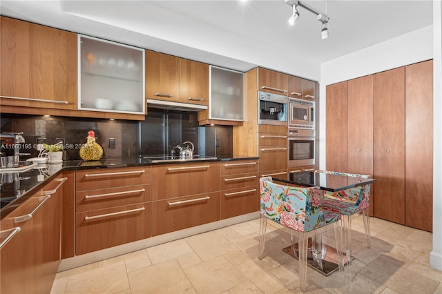 kitchen with decorative backsplash, a kitchen island, stovetop, and stainless steel microwave