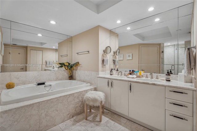 bathroom with vanity, a tray ceiling, and independent shower and bath