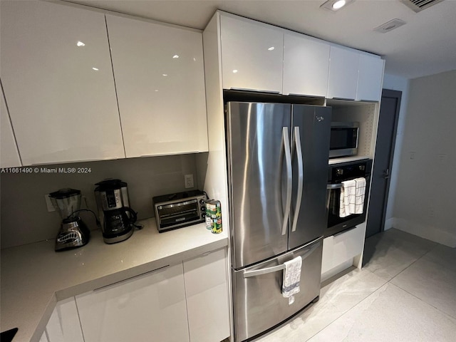 kitchen featuring stainless steel appliances and white cabinetry