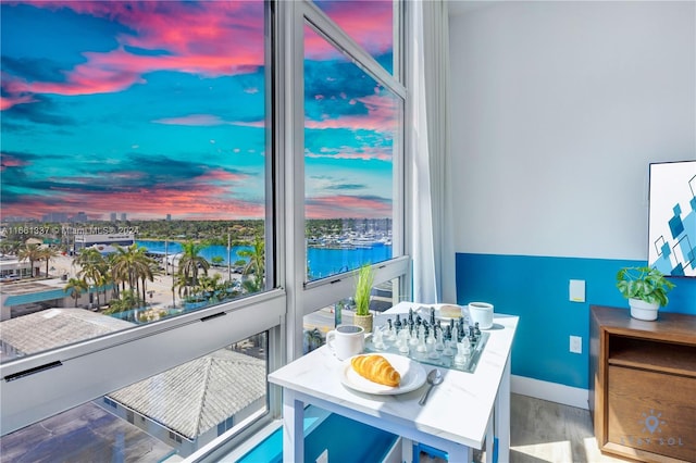 balcony at dusk featuring a water view