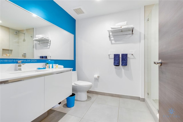 bathroom featuring tile patterned flooring, walk in shower, vanity, and toilet