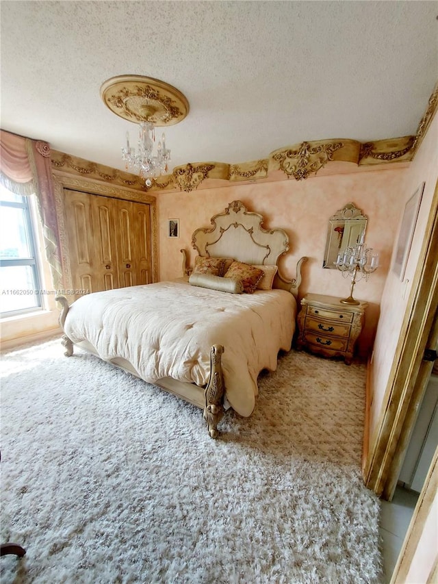 bedroom with a notable chandelier and a textured ceiling