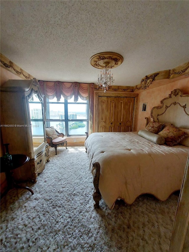 carpeted bedroom with a textured ceiling and a notable chandelier