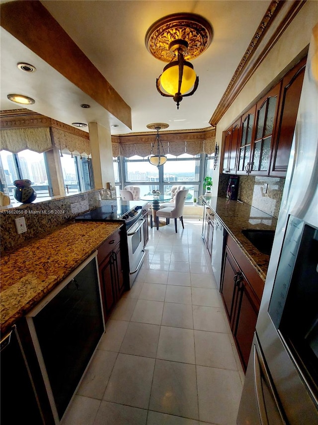 kitchen featuring ornamental molding, tasteful backsplash, decorative light fixtures, stainless steel appliances, and dark stone counters