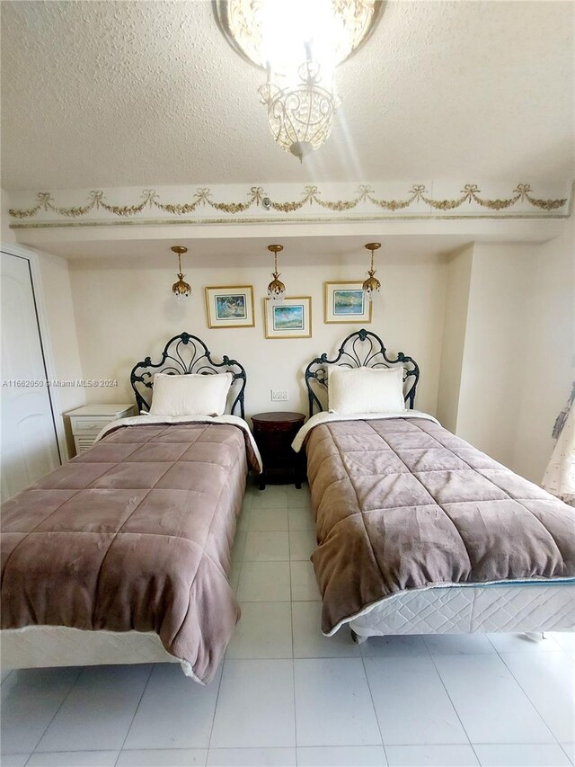 bedroom with a textured ceiling and light tile patterned floors