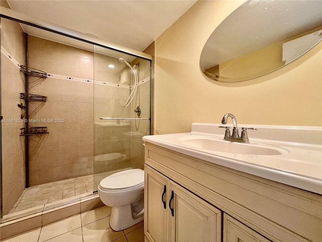 bathroom featuring toilet, vanity, tile patterned floors, and an enclosed shower