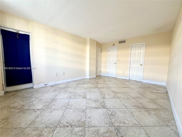 spare room with a textured ceiling