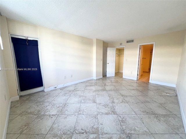 unfurnished room with a textured ceiling