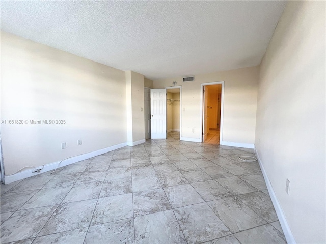 unfurnished room featuring a textured ceiling