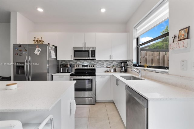 kitchen featuring white cabinets, appliances with stainless steel finishes, sink, and tasteful backsplash