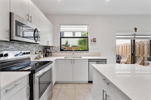 kitchen featuring stainless steel appliances, sink, and white cabinetry