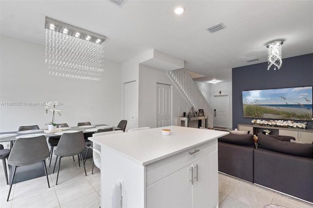 kitchen featuring white cabinets, a chandelier, a center island, and light tile patterned floors