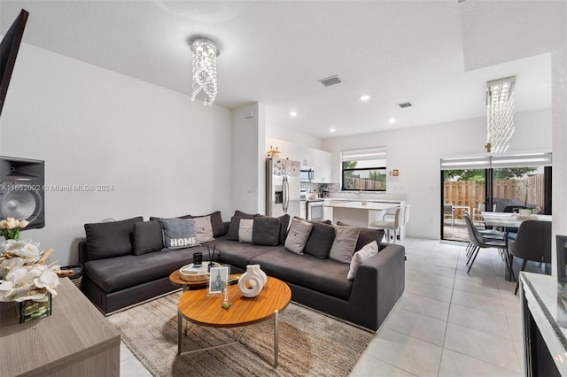 tiled living room with an inviting chandelier