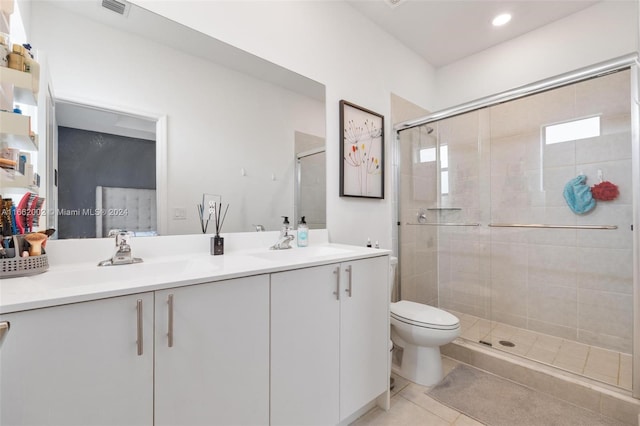 bathroom with tile patterned flooring, vanity, toilet, and a shower with door