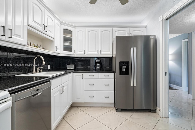 kitchen with appliances with stainless steel finishes, white cabinetry, backsplash, a textured ceiling, and sink