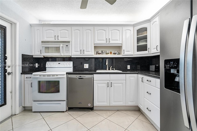 kitchen with sink, tasteful backsplash, a textured ceiling, white cabinetry, and appliances with stainless steel finishes