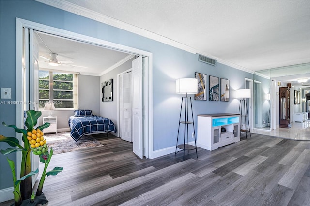 hallway featuring ornamental molding, a textured ceiling, and dark wood-type flooring