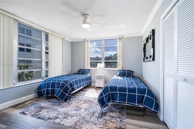 bedroom with ceiling fan, hardwood / wood-style flooring, crown molding, and a textured ceiling