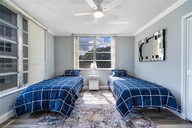 bedroom with ceiling fan, a textured ceiling, crown molding, and dark wood-type flooring