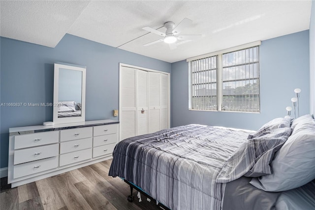 bedroom featuring a closet, light hardwood / wood-style floors, ceiling fan, and a textured ceiling