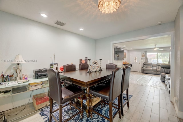 dining room featuring ceiling fan with notable chandelier