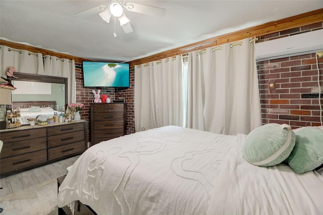 bedroom featuring brick wall, light hardwood / wood-style flooring, and ceiling fan