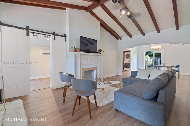 living room featuring high vaulted ceiling, a fireplace, beamed ceiling, a barn door, and light wood-type flooring