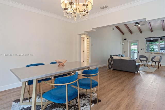 dining area featuring crown molding, lofted ceiling with beams, light hardwood / wood-style flooring, and a notable chandelier