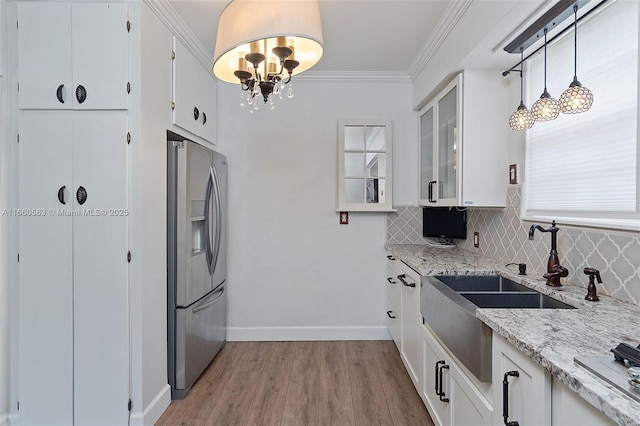 kitchen featuring hanging light fixtures, crown molding, white cabinets, and stainless steel refrigerator with ice dispenser