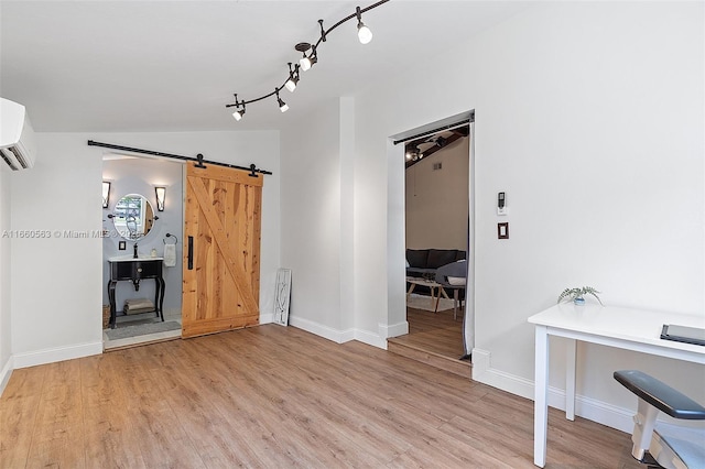 interior space with lofted ceiling, a barn door, a wall mounted AC, and light wood-type flooring