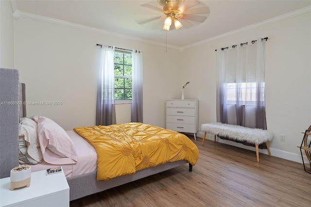 bedroom with wood-type flooring, ornamental molding, and ceiling fan