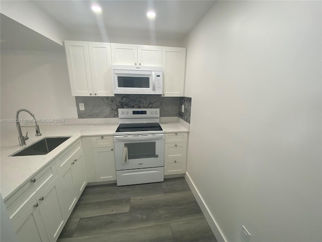 kitchen featuring tasteful backsplash, white appliances, dark wood-type flooring, sink, and white cabinets