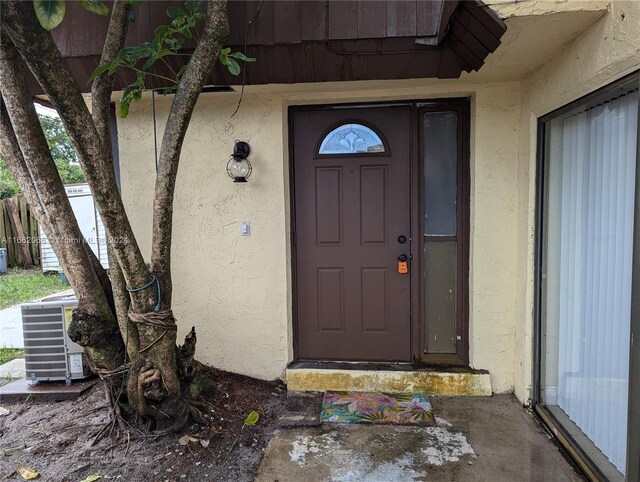 view of exterior entry featuring central air condition unit