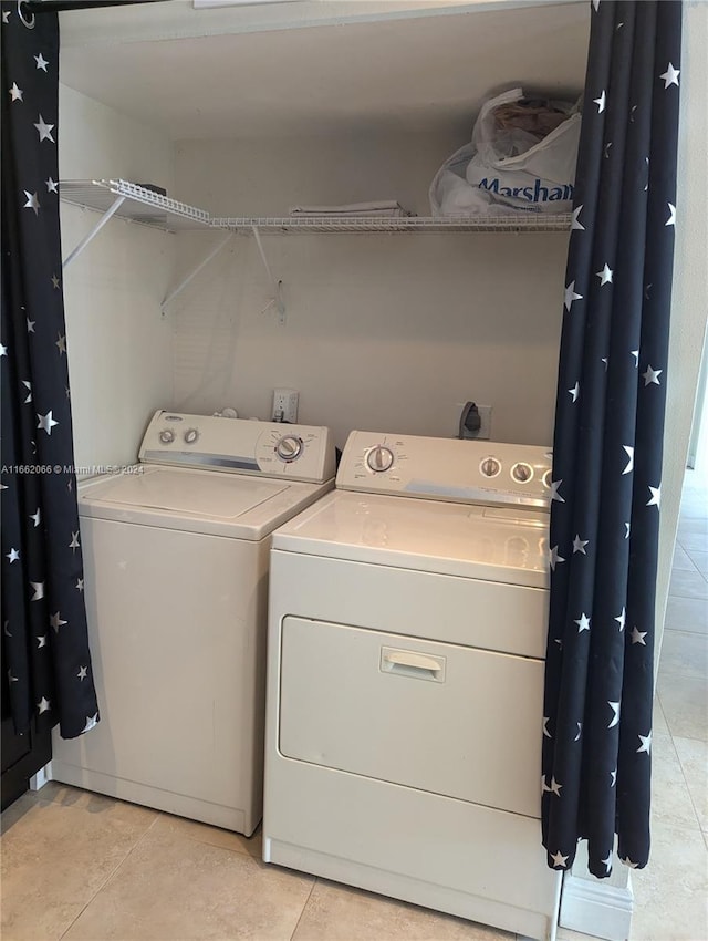 laundry room featuring washer and clothes dryer and light tile patterned floors