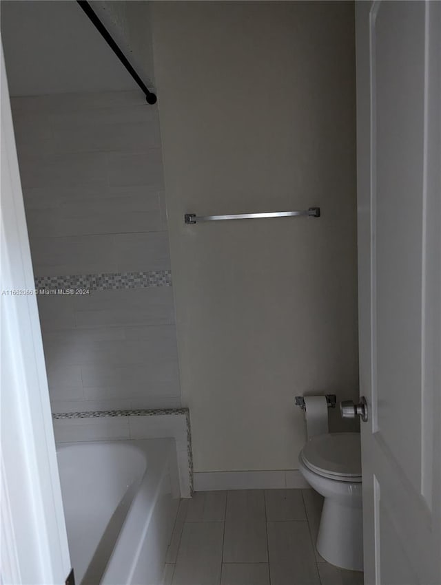 bathroom with toilet, tile patterned floors, and a bathing tub