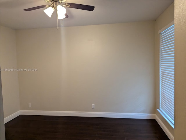 empty room featuring ceiling fan, dark hardwood / wood-style floors, and a healthy amount of sunlight