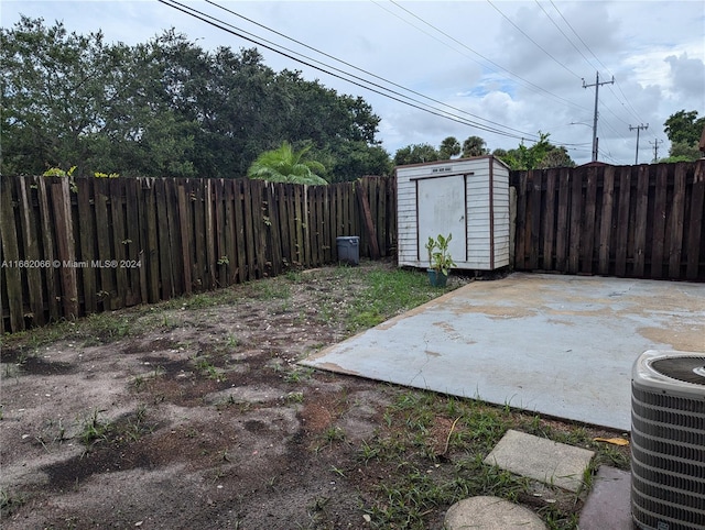 view of yard featuring a storage unit, central air condition unit, and a patio area