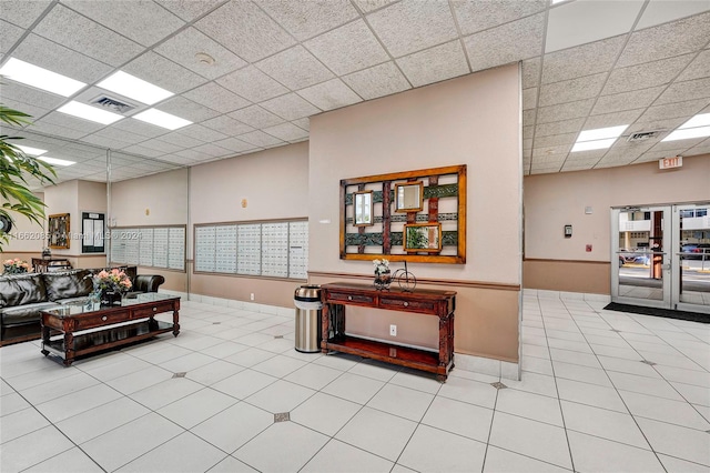 living room featuring a paneled ceiling and light tile patterned floors