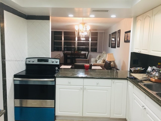 kitchen featuring hanging light fixtures, white cabinetry, stainless steel electric range, an inviting chandelier, and dark stone counters