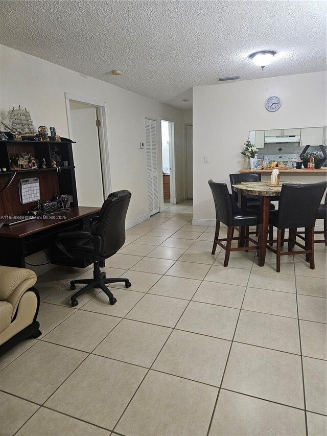 dining room featuring a textured ceiling and light tile patterned floors