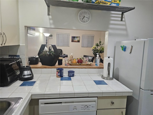 kitchen featuring white appliances and tile counters