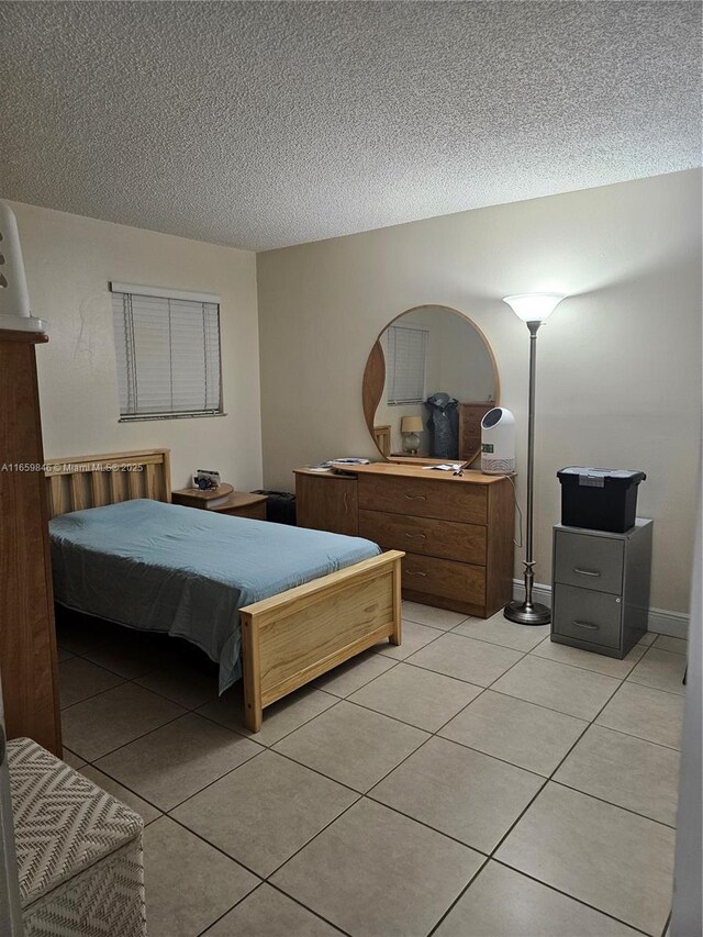 tiled bedroom featuring a textured ceiling