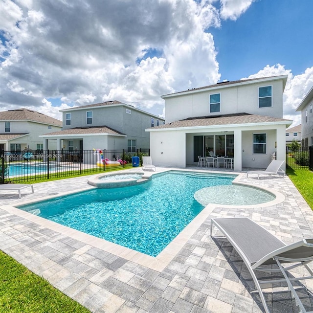 view of swimming pool featuring an in ground hot tub and a patio area