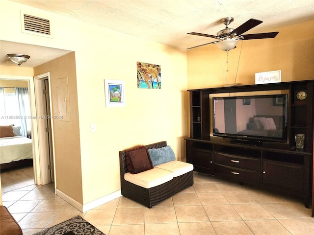 sitting room with ceiling fan, light tile patterned flooring, and a textured ceiling