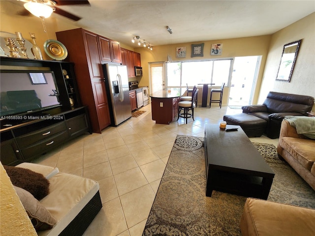 tiled living room with ceiling fan